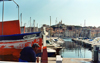 France - Marseilles (Bouches-du-Rhone / PACA): sailor in the habour - church in the background (photo by G.Frysinger)